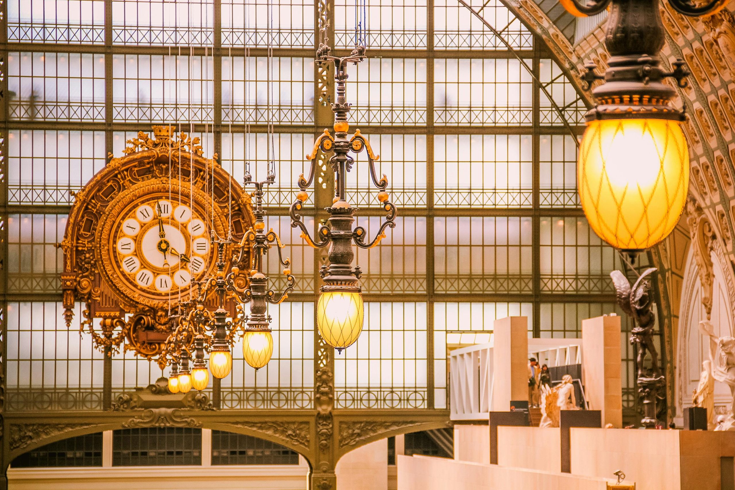 Close-up of the ornate clock and interior architecture of Musée d'Orsay, Paris, with warm lighting.